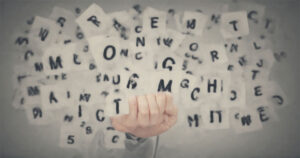 A person holding a card with the words "Profitable Marketing Niches" surrounded by scattered letters