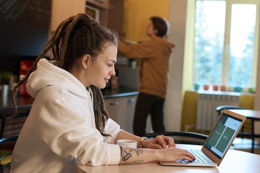 Young woman works on a laptop for fiverr in a casual environment.